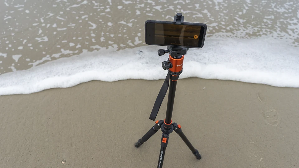 Teléfono móvil sobre un trípode conectado junto al mar