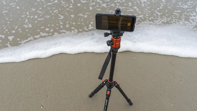 Teléfono móvil sobre un trípode conectado junto al mar