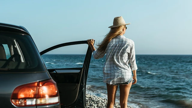 Viajera junto a un carro durante un recorrido por la costa